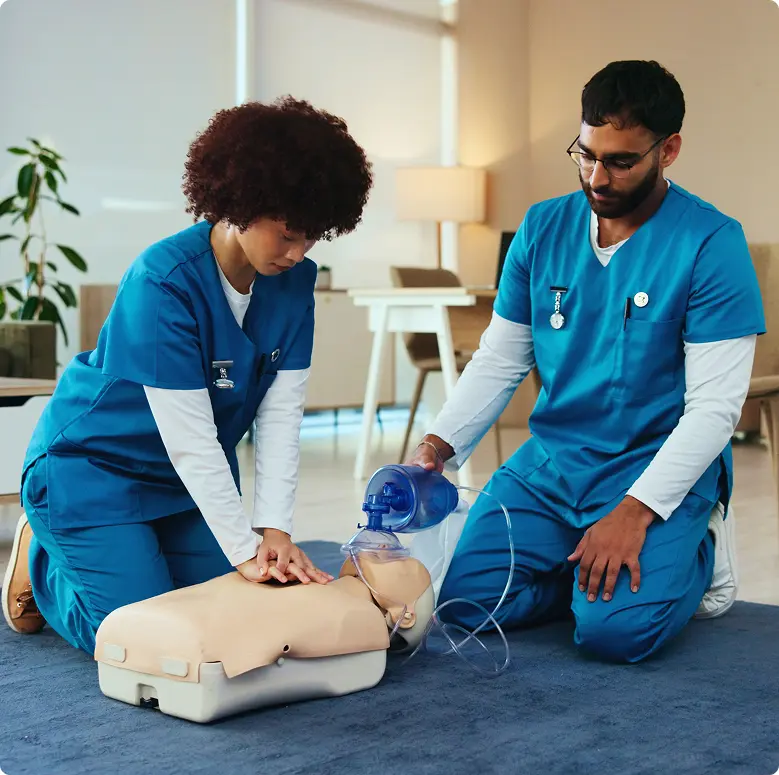 Two nurses performing CPR in classroom setting