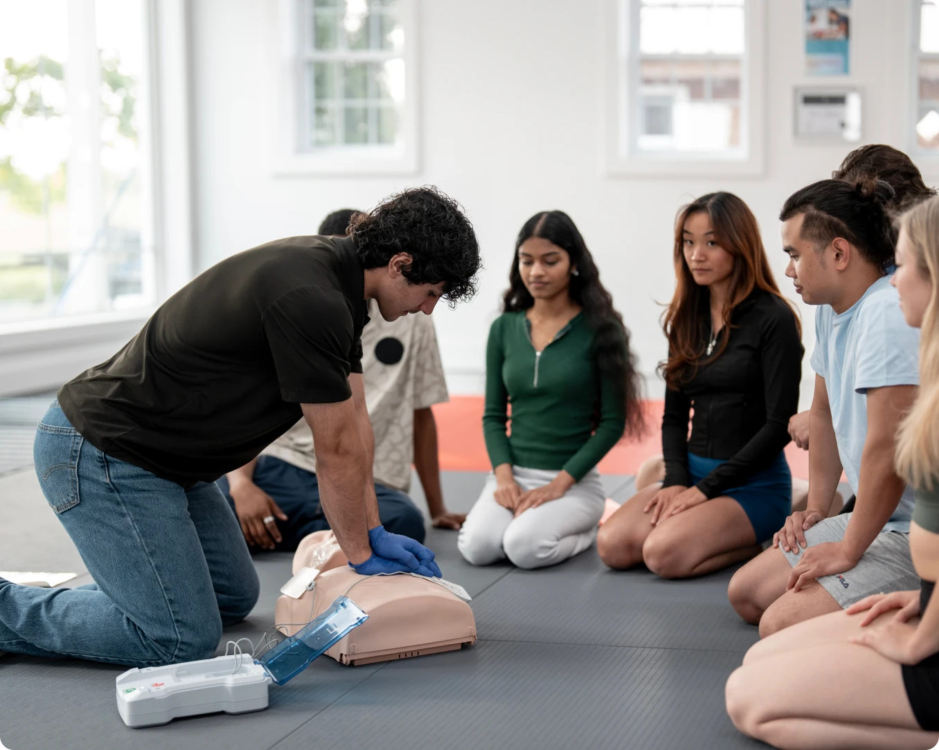 Group learning CPR techniques indoors
